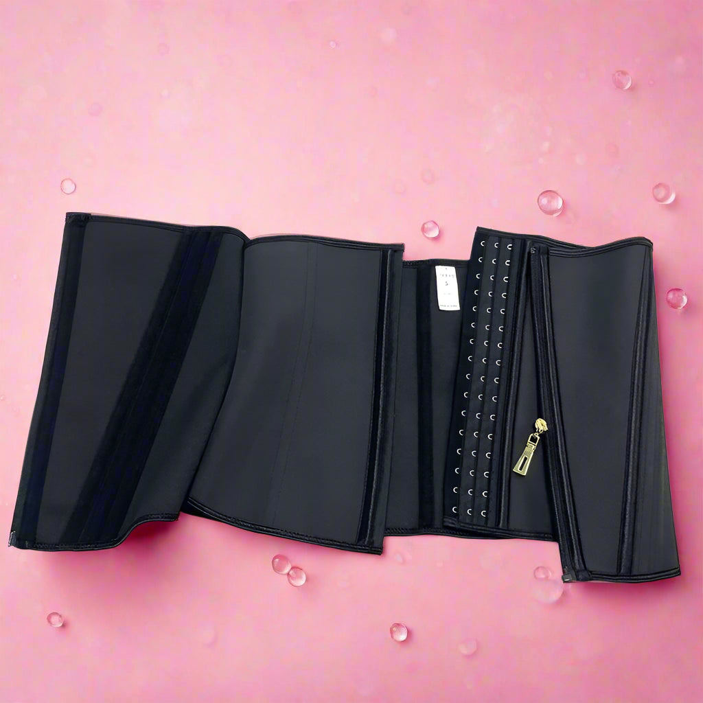 Black waist trainer with studded details on a pink bubbly background